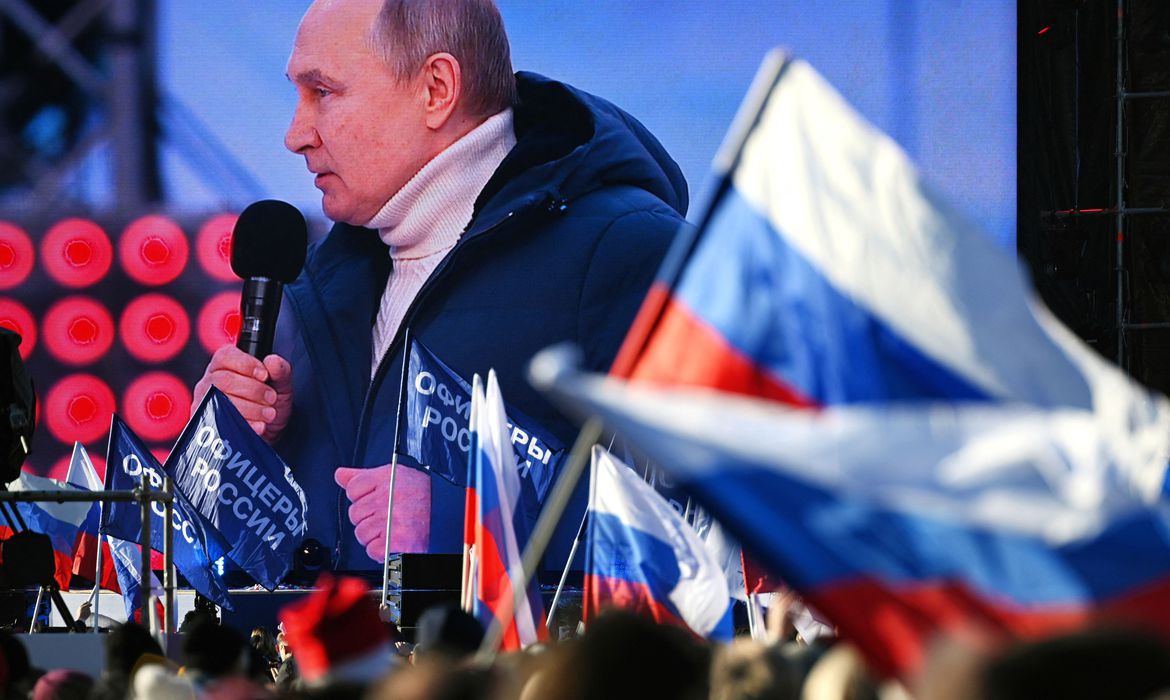Russian President Vladimir Putin is seen on a screen as he delivers a speech during a concert marking the eighth anniversary of Russia's annexation of Crimea outside Luzhniki Stadium in Moscow, Russia March 18, 2022. RIA Novosti Host Photo Agency/Vladimir Astapkovich via REUTERS