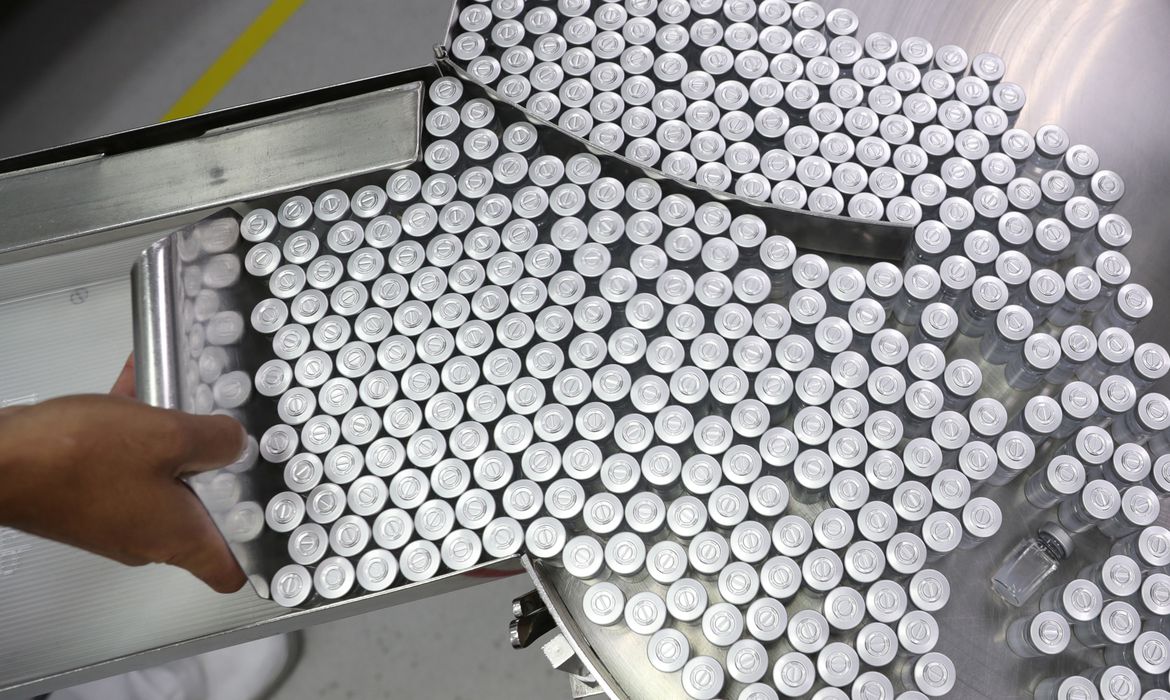 An employee puts on an equipment vials containing CoronaVac, Sinovac's vaccine against the coronavirus disease (COVID-19), at Butantan biomedical production center in Sao Paulo, Brazil January 22, 2021. REUTERS/Amanda Perobelli